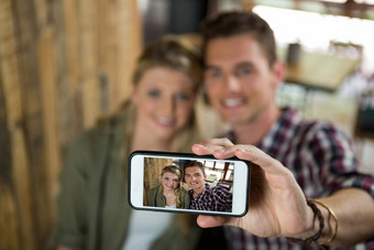 微笑夫妇采取自拍手机自助餐厅