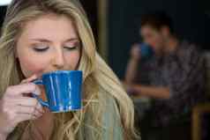 年轻的女人喝咖啡自助餐厅