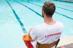 救生员坐着椅子救援浮标在游泳池边