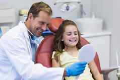 牙医显示镜子年轻的病人牙科诊所