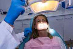 女人说谎牙医椅子牙医调整电灯