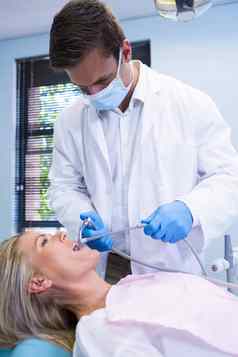 牙医清洁女人牙齿站墙