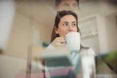 女人喝咖啡坐着玻璃表格