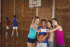高学校女孩采取自拍篮球法院