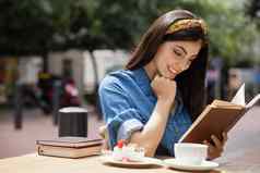 女人阅读书坐着咖啡馆