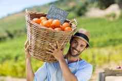 肖像微笑农民携带新鲜的橙子容器