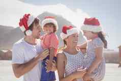 快乐孩子们父母穿圣诞老人他海滩