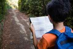 男孩阅读地图走路径