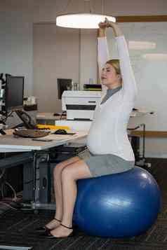 怀孕了女人执行伸展运动锻炼健身球