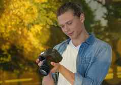 年轻的赶时髦的人摄影师照片相机公园散景重叠
