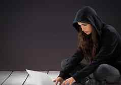 女人黑客移动PC前面紫色的背景