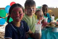 微笑孩子们脸油漆坐着食物饮料公园