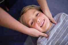 肖像微笑男孩接收脖子按摩女治疗师
