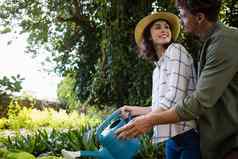 浪漫的夫妇浇水植物浇水花园