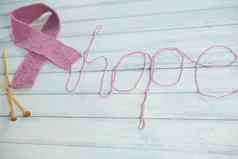 高角视图粉红色的乳房癌症意识丝带希望文本用钩针编织针