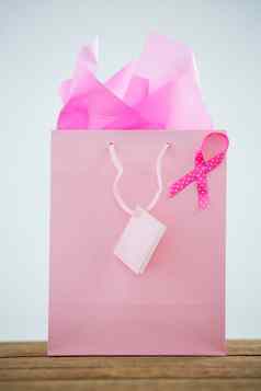 特写镜头粉红色的乳房癌症意识丝带购物袋木表格
