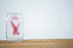 特写镜头粉红色的乳房癌症意识丝带玻璃Jar