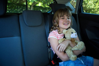 十几岁的女孩泰迪熊坐着回来座位车