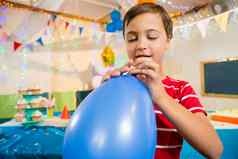 可爱的男孩持有蓝色的气球生日聚会，派对