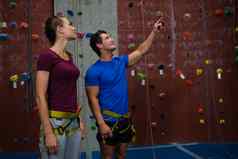 教练指导运动员攀爬墙健身房