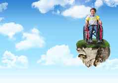 年轻的男孩浮动岩石平台天空轮椅