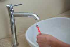 手女人洗牙刷水槽