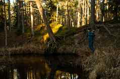 渔夫垂钓者钓鱼森林河蓝色的服装抓鳟鱼