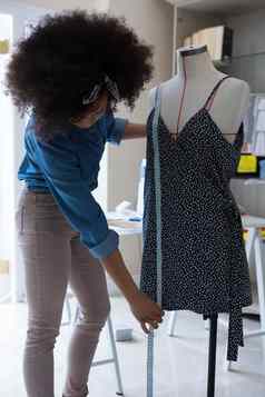 女设计师测量长度衣服人体模型