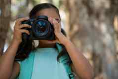 女孩背包采取照片数码单反相机相机森林