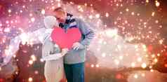 复合图像快乐成熟的夫妇冬天衣服持有红色的心