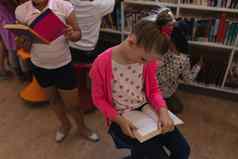 女学生阅读书坐着椅子学校图书馆