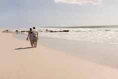 浪漫的年轻的夫妇走海滩鞋子海滩