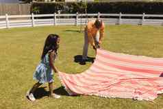 祖父（外）孙女放置野餐毯子后院