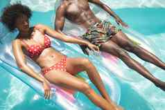年轻的非洲美国夫妇放松池懒人游泳池