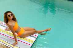女人太阳镜坐着边缘游泳池