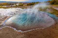 间歇泉金圆冰岛深蓝色的水地热池热气腾腾的热咸地壳布莱西
