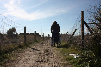 孤独的人推轮椅桑迪路径领导海沙丘