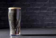 黑暗爱尔兰干结实的啤酒玻璃黑色的砖背景