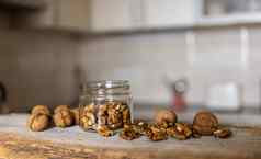 胡桃木Jar分散坚果站白色古董表格厨房背景核桃健康的素食者蛋白质有营养的食物胡桃木乡村木