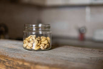 腰果坚果Jar站白色古董表格厨房背景腰果螺母健康的素食者蛋白质有营养的食物