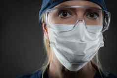 女医疗工人穿保护脸面具齿轮黑暗背景