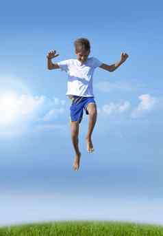 男孩跳跃夏天背景蓝色的天空