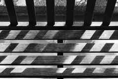 黑色的白色花园木板凳上一天光影子