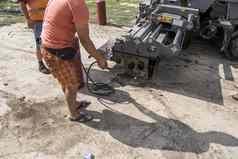 男人。火气体油缸订单融化干沥青沥青摊铺机机路建设修复作品准备设备工作