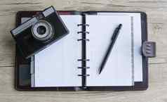 开放棕色（的）笔记本笔照片相机木背景白色纸木表格模拟笔记本摄影师