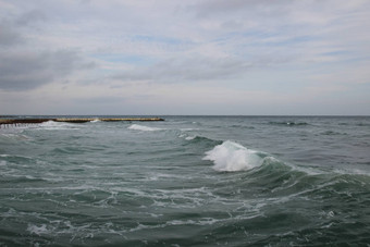 空海滩黑色的海多云的秋天天气景观狂风暴雨的海波打破空野生海滩多云的天空阴一天