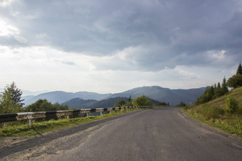 弯曲的蜿蜒的山森林路乌克兰喀尔巴阡山脉的沥青高速公路山蓝色的天空空沥青路高速公路草木丛生的山背景多云的天空