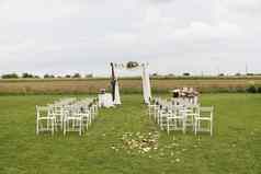 美丽的婚礼仪式场白色椅子的地方婚礼仪式婚礼拱装饰布花白色椅子一边拱门在户外