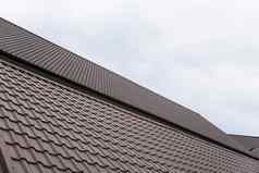 现代屋顶覆盖瓷砖效果聚氯乙烯涂层棕色（的）金属屋顶表多云的天空