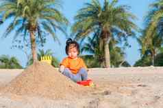 快乐的女儿女孩有趣的挖掘玩玩具沙子